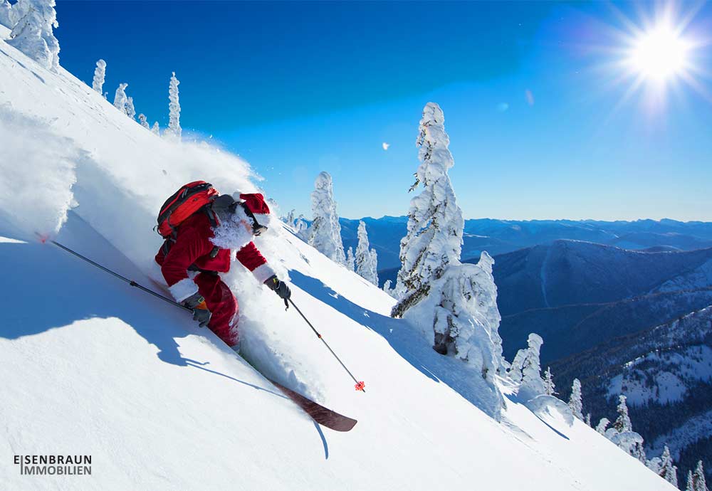 Frohe Weihnachten wünscht Eisenbraun Immobilien. Das Bild zeigt einen skifahrenden Weihnachtsmann.