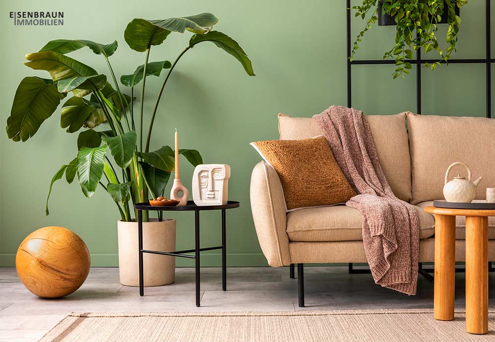 Home Staging: Das Foto zeigt ein geschmackvolle helle Couch vor einer hellgrünen Wand.